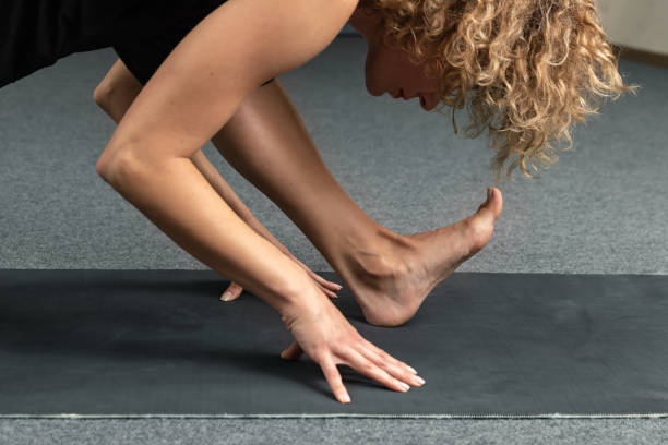 istock Woman practicing yoga, doing Half splits exercise at yoga studio, Ardha Hanumanasana pose, working out, wearing sportswear, black pants, close up. Healthy lifestyle concept 1209118619