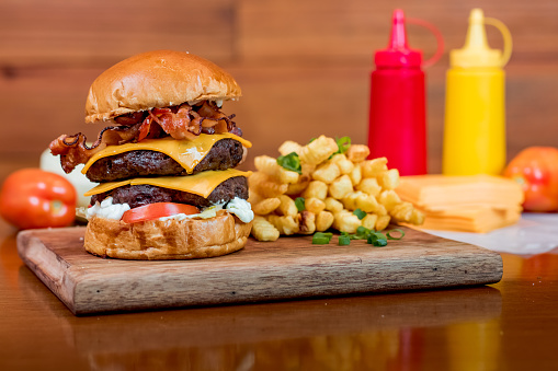 Double Cheeseburger and Fries on a wood table.