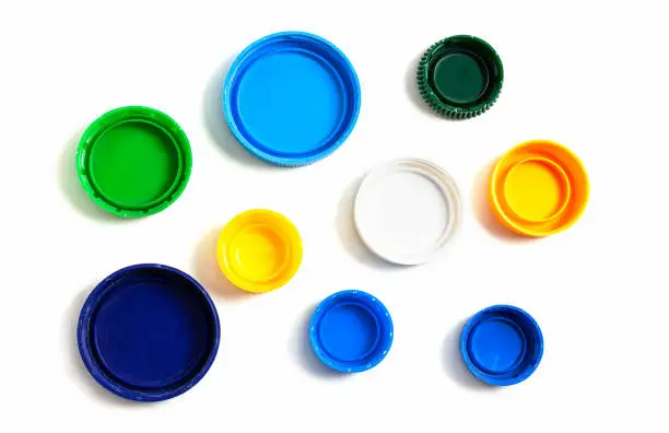 Photo of Colored plastic caps from bottles of water isolated on a white background.