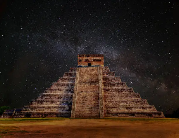 Mayan pyramid of Kukulcan El Castillo in Chichen Itza, Mexico at Night with Milky Way galaxy. A World Heritage Site, it is also one of the New Seven Wonders of the World.