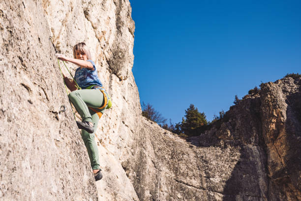 istock Woman climbs a rock. 1209129377