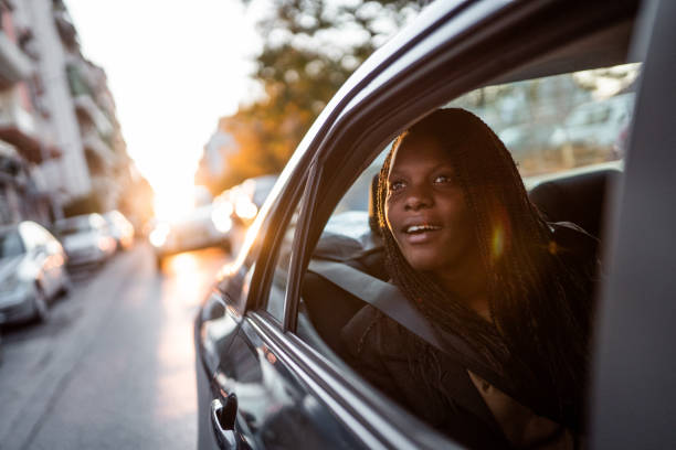 istock Young woman sitting in car and looking through window from back seat 1209137049