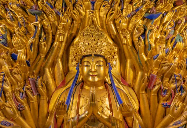 Golden sculpture of Avalokiteshvara Buddha or Guanyin with thousand hands at Dazu Rock Carvings at Mount Baoding or Baodingshan in Dazu, Chongqing, China. UNESCO World Heritage Site.