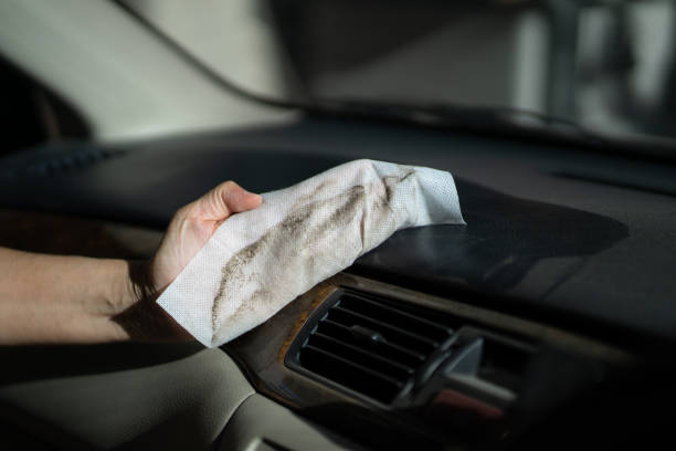 istock hand with dirty dust in microfiber cloth cleaning console in front of car 1209140903