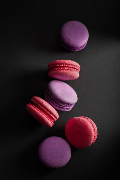 istock Multi-colored macaroons scattered on a dark background. International Women's Day. French national cuisine. 1209145074