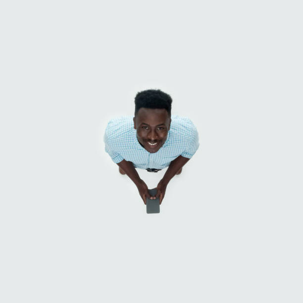 istock Caucasian male standing in front of white background and using mobile phone 1209148393