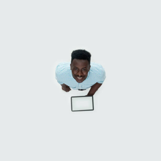 istock Caucasian young male standing in front of white background and using digital tablet 1209148430