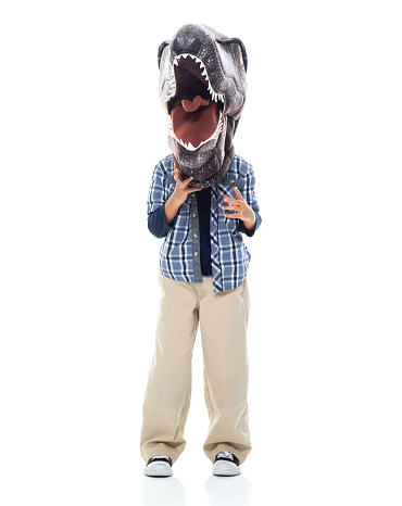 Full length of boys standing in front of white background wearing mask - disguise and wearing wearing dinosaur mask mask