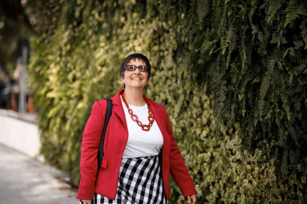 mujer mayor disfrutando de un paseo frente a un jardín vertical - senior women cheerful overweight smiling fotografías e imágenes de stock