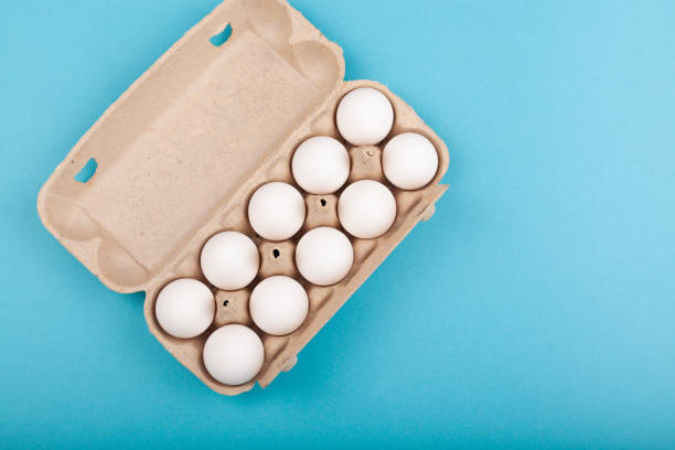 istock Egg Chicken eggs. Top view of an open gray box with white eggs. Isolated on a blue background. The concept of a healthy lifestyle, getting pure protein. Proper Breakfast. Preparing for Easter 1209148899