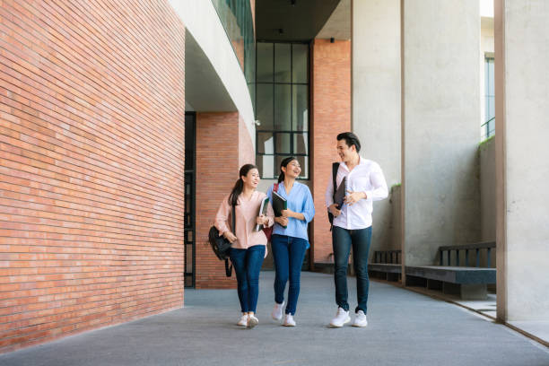 istock Asian three students are walking and talking together in university hall during break in University. Education, Learning, Student, Campus, University, Lifestyle concept. 1209150241