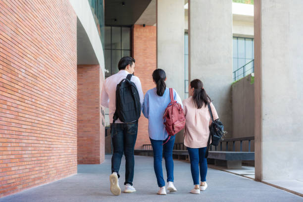 istock Asian three students are walking and talking together in university hall during break in University. Education, Learning, Student, Campus, University, Lifestyle concept. 1209150242