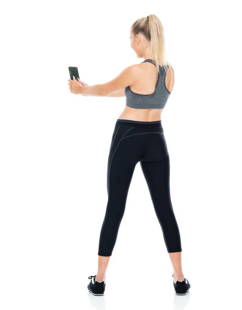 istock Generation z young women standing in front of white background wearing bra and using mobile phone 1209153964