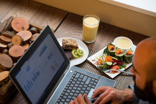 istock Man working on laptop while eating a vegan meal 1209154205