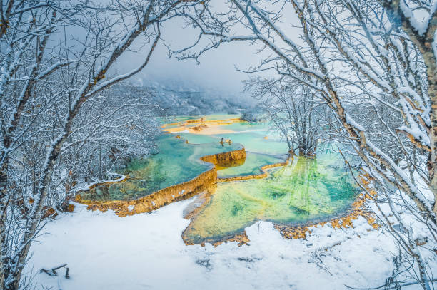 schöne naturlandschaft von huang long und jiuzhaigou park nationalpark mit herrlichem schnee in sichuan , china - winter stream river snowing stock-fotos und bilder