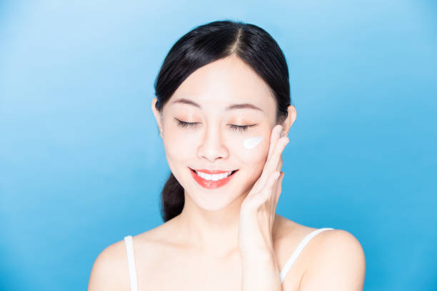 istock woman apply sunscreen on face 1209154992