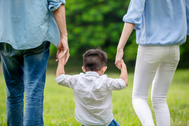 młodzi rodzice chodzący z dzieckiem - asian ethnicity male park men zdjęcia i obrazy z banku zdjęć