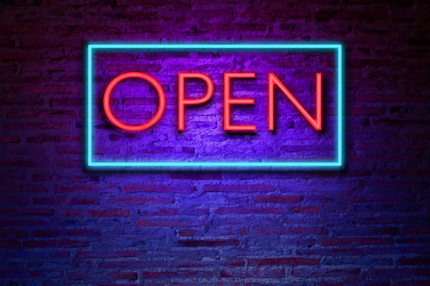 realistic neon text Open on the brick wall. stock photo