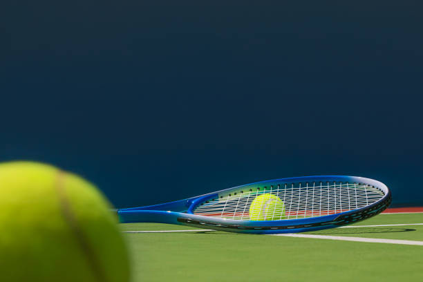 Tennis racket and tennis ball on court stock photo