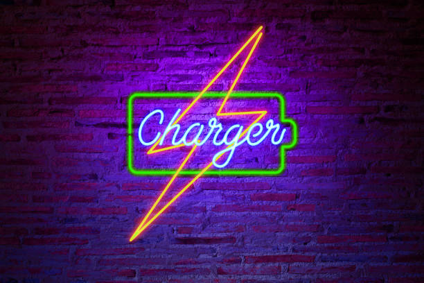 colorful neon battery charger sing photo on brick wall stock photo