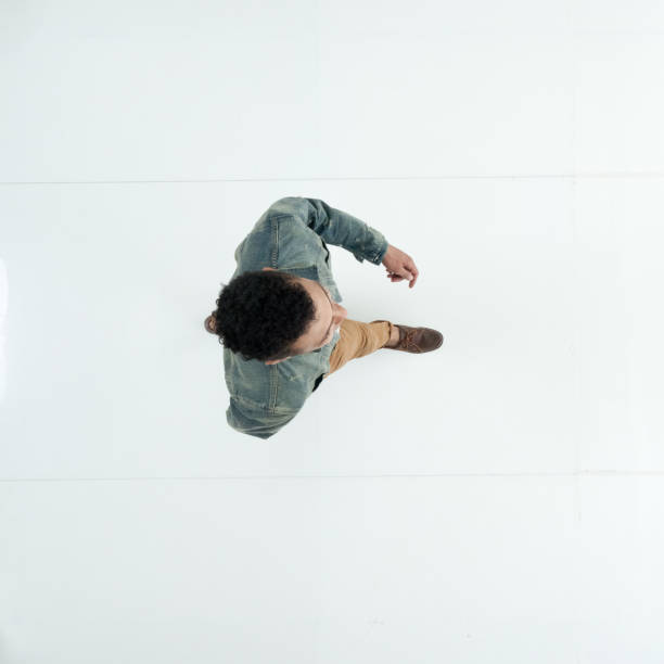 istock Young male walking in front of white background wearing denim jacket 1209155362