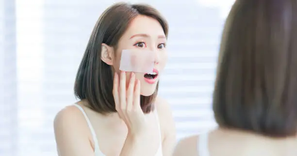 Photo of woman use oil blotting paper