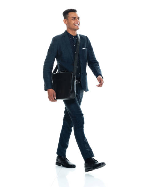 African-american ethnicity young male businessman walking in front of white background wearing satchel - bag and holding bag Side view of aged 20-29 years old with black hair african-american ethnicity young male businessman walking in front of white background wearing satchel - bag who is cheerful and holding bag shoulder bag stock pictures, royalty-free photos & images