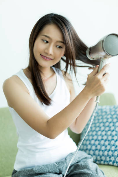 istock Young woman drying her hair 1209158388