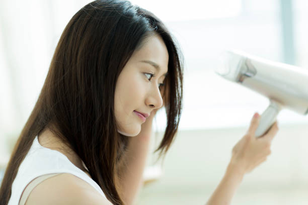 istock Young woman drying her hair 1209158423