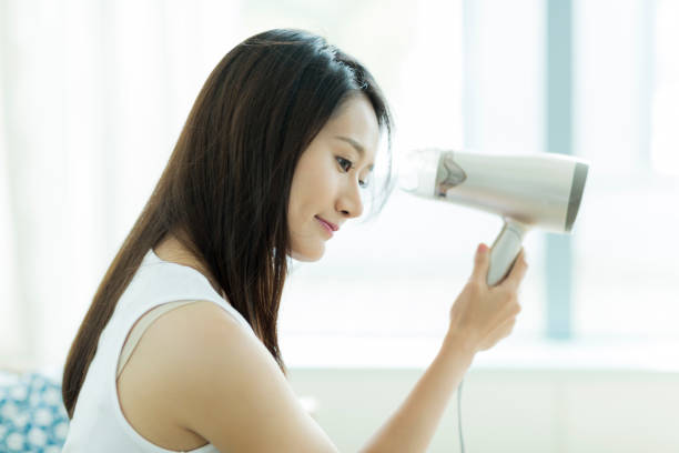 istock Young woman drying her hair 1209158447