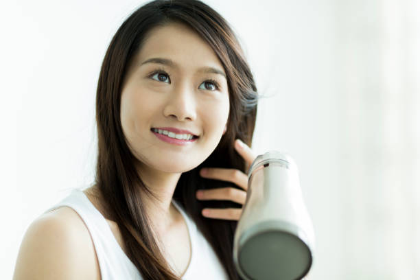 istock Young woman drying her hair 1209158990