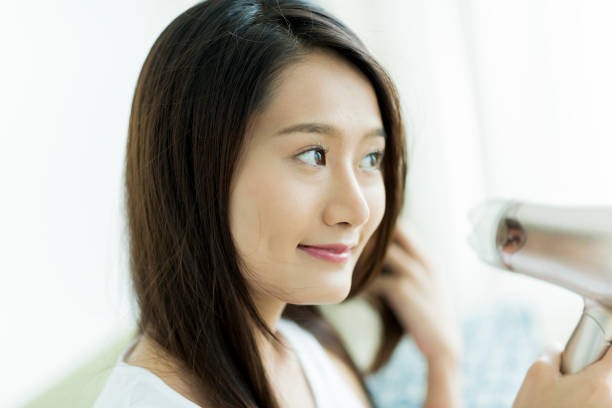 istock Young woman drying her hair 1209159016