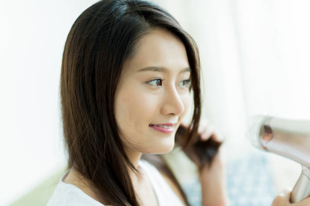 istock Young woman drying her hair 1209159020