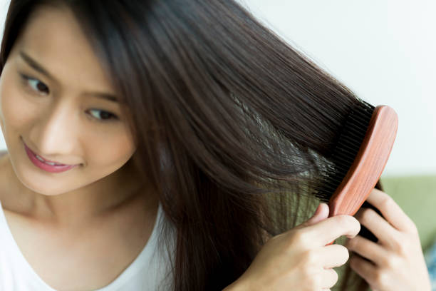 istock Young woman brushing hair 1209159036