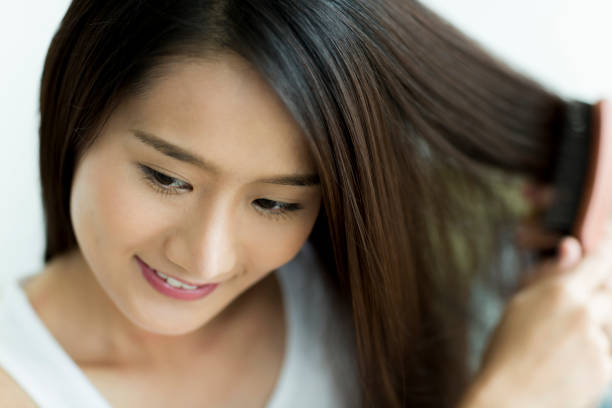 istock Young woman brushing hair 1209159061