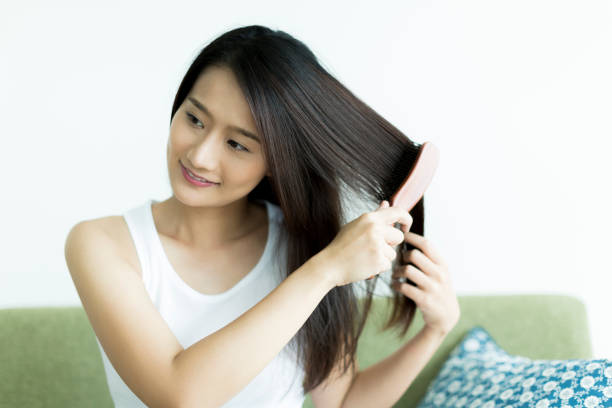 istock Young woman brushing hair 1209159297