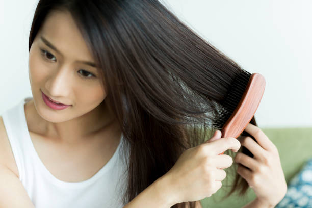 istock Young woman brushing hair 1209159299