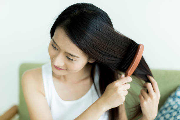 istock Young woman brushing hair 1209159320