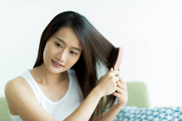 istock Young woman brushing hair 1209159429