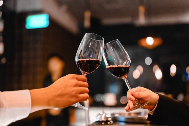 dos camareros disfrutando de cheers copa de vino para el evento de cata de vinos en un restaurante al atardecer. camarero, degustación, cena, vino, bebida, concepto de cena. - wine red wine pouring wineglass fotografías e imágenes de stock