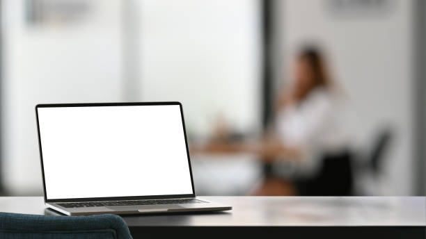 istock Computer laptop with white blank screen putting on modern working desk with blurred background. 1209159678