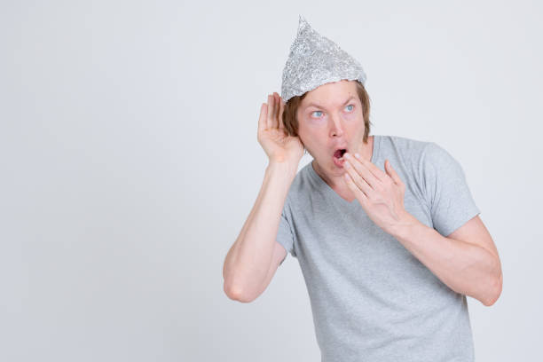 istock Young man with tin foil hat listening and looking shocked 1209163089