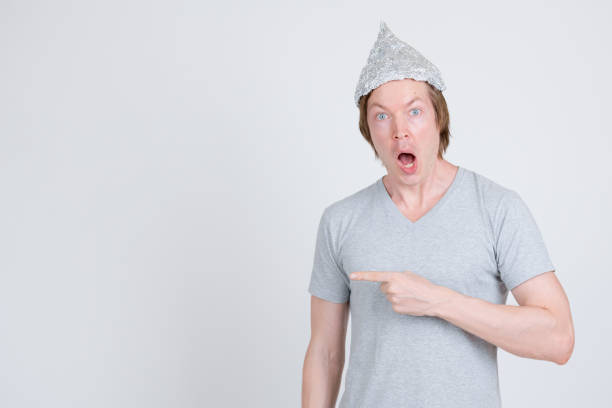 istock Shocked young man with tinfoil hat as conspiracy theory concept pointing to side 1209163112