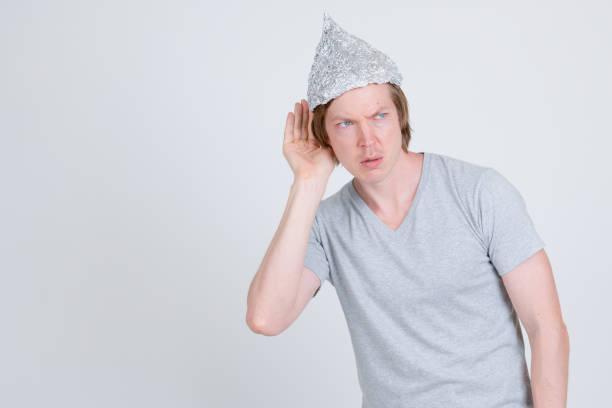 istock Young man with tin foil hat thinking and listening 1209163149