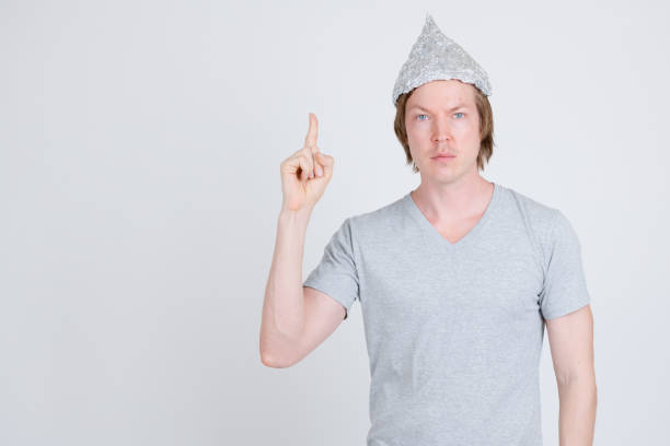 istock Young man with tinfoil hat as conspiracy theory concept pointing up 1209163200