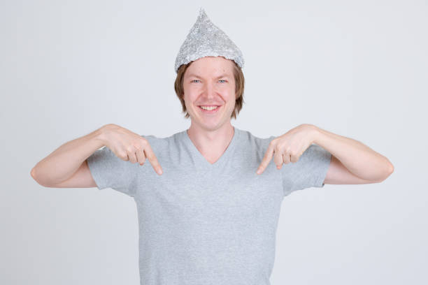istock Happy young man with tin foil hat pointing at shirt 1209163228