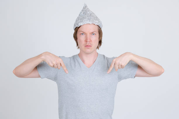 istock Young man with tin foil hat pointing at shirt 1209163272