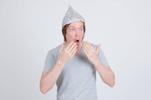 istock Young man with tinfoil hat as conspiracy theory concept looking shocked 1209163297