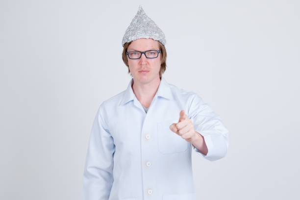 istock Young man doctor with tinfoil hat pointing at camera 1209163576