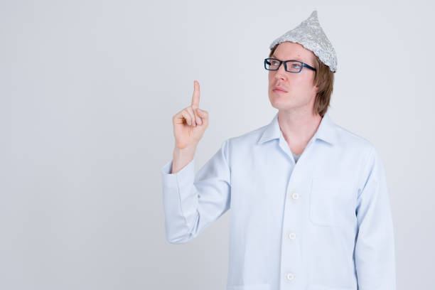 istock Young man doctor with tinfoil hat thinking and pointing up 1209163698